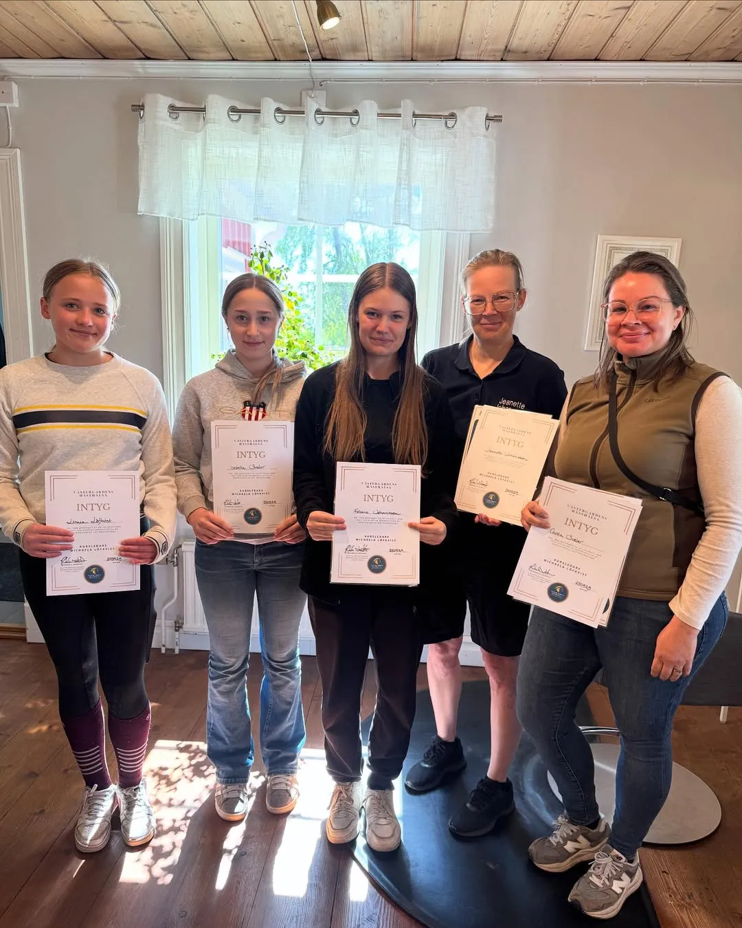 Kursdeltagare håller upp sina intyg från kursen Prehab och Hästmassage hos Västergårdens hästhälsa